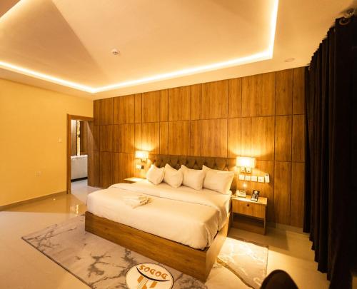 a bedroom with a large bed with a wooden wall at Dodos Hotel Services in Port Harcourt
