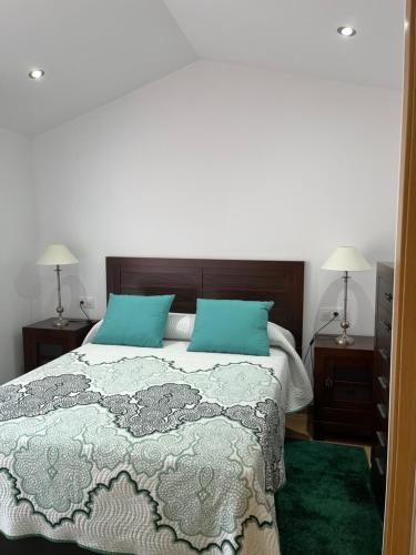 a bedroom with a bed with two night stands and two lamps at Ático en pleno centro en Cangas in Cangas de Morrazo