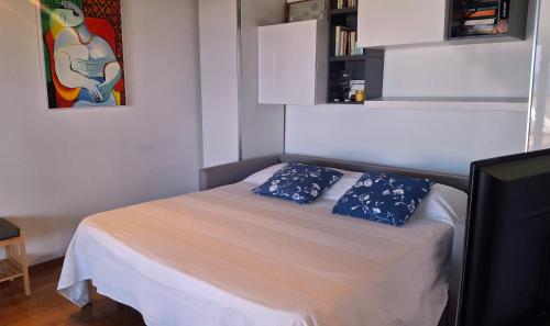 a bedroom with a bed with two blue pillows on it at Terrazza Tosti in Formia
