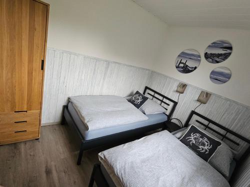 a bedroom with two beds and a closet at Boddenhaus Stahlbrode in Reinberg