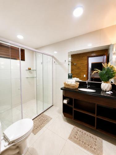 a bathroom with a toilet and a sink and a shower at NaPraia Brasil Pousada in São Miguel do Gostoso