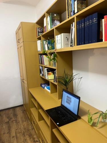 a laptop computer sitting on a desk in a book shelf at Bookworm Ultracentral Cozy, ultracentral apartment for people who appreciate comfort, details and books in Târgu-Mureş
