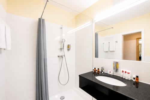 ein weißes Badezimmer mit Dusche und Waschbecken in der Unterkunft Hotel Rivoli Charme in München
