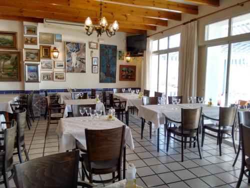 une salle à manger avec des tables blanches, des chaises et des fenêtres dans l'établissement Hotel San Miguel, à Altea