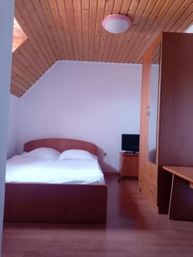 a bedroom with a bed and a wooden ceiling at Casa Daniela in Horezu