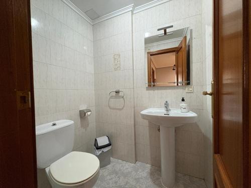 a bathroom with a white toilet and a sink at La casita de Isa in Ciudad-Rodrigo