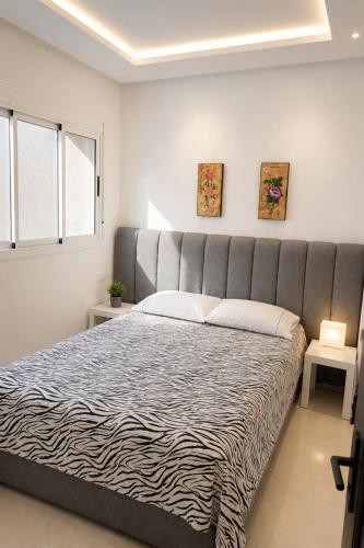 a bedroom with a large bed with a large headboard at Appartement MIRAMAR in Martil