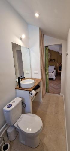 a bathroom with a white toilet and a sink at La Casita in Avignon