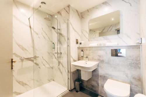 a bathroom with a shower and a sink and a toilet at The Lodge Hotel in Coleraine