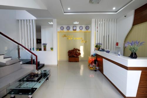a lobby with a staircase and a yellow wall at The Times Hotel in Hue