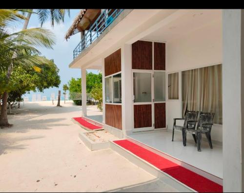 a house on the beach with chairs and a table at PP Beach Villa in Agatti
