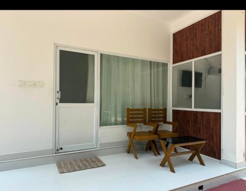 a room with two chairs and a table and windows at PP Beach Villa in Agatti