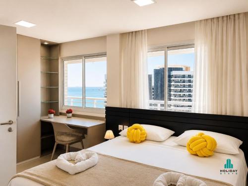 a bedroom with two beds with yellow pillows and a desk at My Way by Holiday Stays in Fortaleza