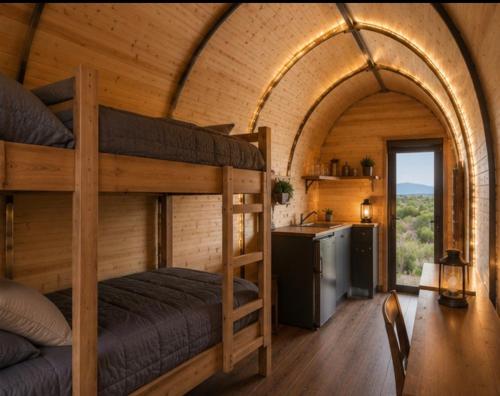 a bedroom with two bunk beds and a kitchen at Sauron Adventure Bungaloft in Villa Carlos Paz