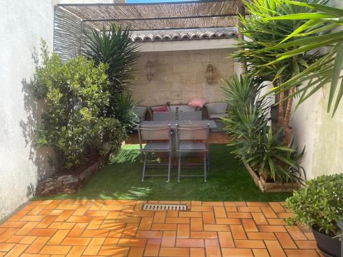 a patio with a table and chairs in a yard at La Saline in Aigues-Mortes
