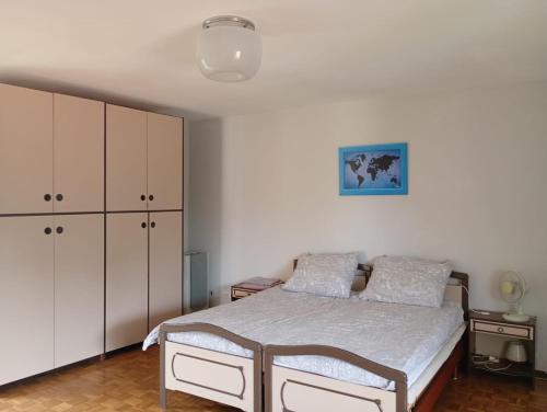 a bedroom with a bed and white cabinets at Casa Anna in Crosa