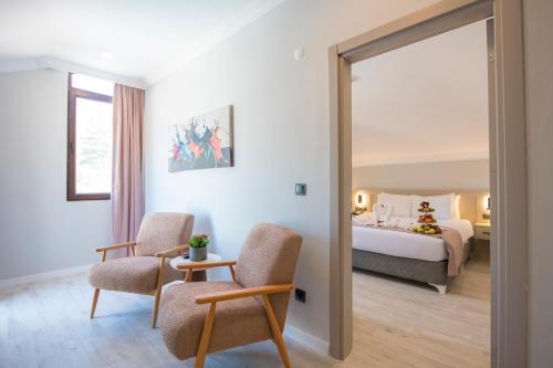 a hotel room with a bed and two chairs at Casa De Levıssı Ölüdeniz in Oludeniz