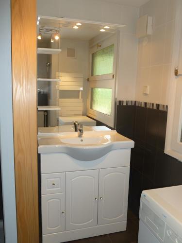 a bathroom with a white sink and a mirror at Gîte Les Hambostures in Lapoutroie