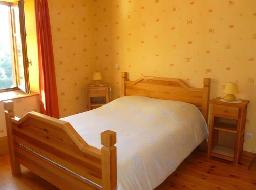 a bedroom with a wooden bed and two night stands at Gîte Les Hambostures in Lapoutroie