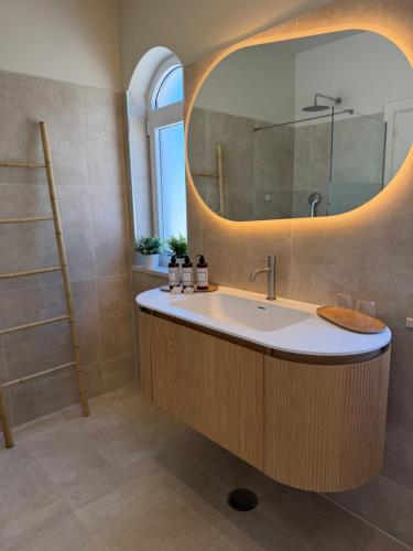 a bathroom with a sink and a mirror at Boutique Guesthouse-Moncarapacho in Moncarapacho