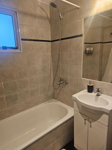 a bathroom with a tub and a sink and a bath tubermottermott at Palermo Apart 2 in Buenos Aires