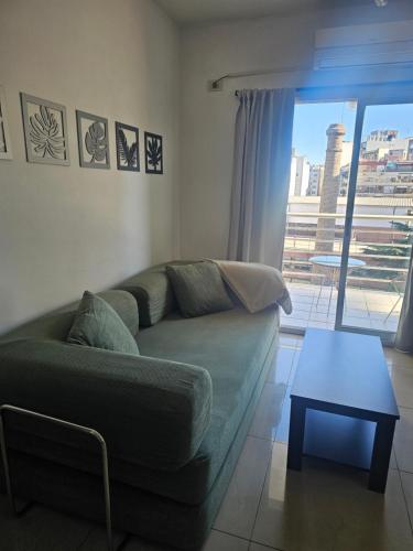 a living room with a green couch and a table at Palermo Apart 2 in Buenos Aires