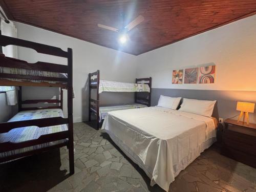a bedroom with a bed and two bunk beds at Chalés Talismã in Caconde