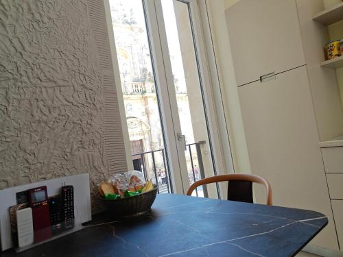 a blue table with a bowl of bread and a window at Palazzo Lanzilao's Rooms in Lecce