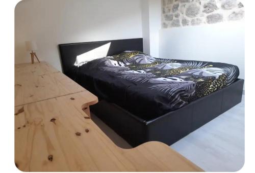 a black bed in a room next to a wooden table at Duplex centre historique frejus in Fréjus
