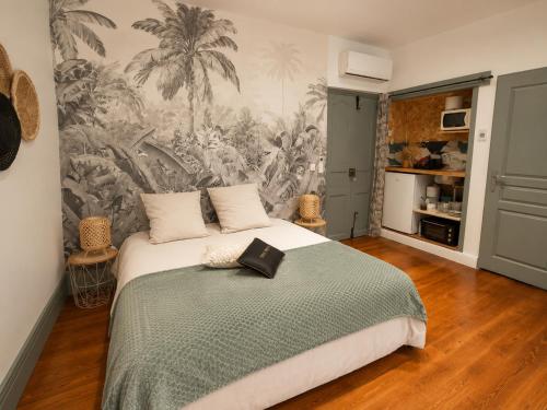 a bedroom with a bed and a mural of palm trees at Plan B - Chambres & Studios in Saint-Jean-Pied-de-Port