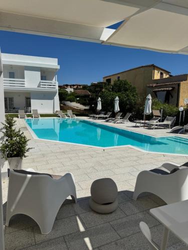 a large swimming pool with chairs and a table at Al Mare da Francesca in Olbia