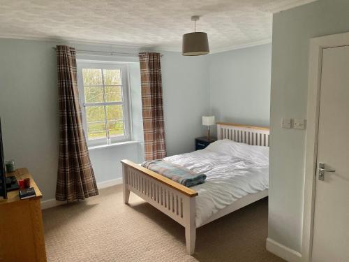 a bedroom with a bed and a window at The Bognie Inn in Huntly