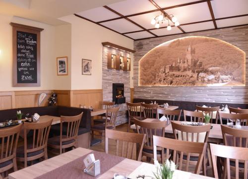 a restaurant with tables and chairs and a chalkboard on the wall at Weinhaus Gräfen in Cochem