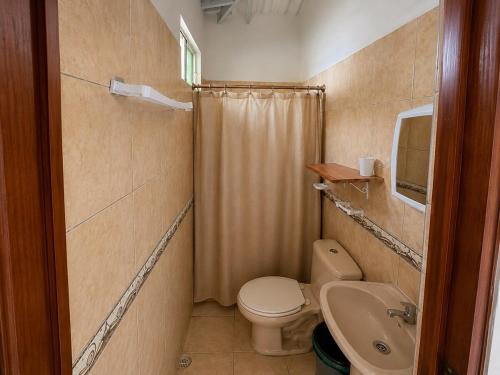 a small bathroom with a toilet and a sink at Hospedaje Isabela in Puerto Villamil
