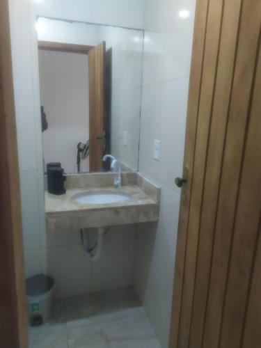 a bathroom with a sink and a mirror at EBORA cultura afro in Ilhéus