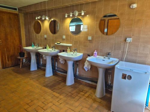 a bathroom with three sinks and two mirrors at Les Cabanes d Erhes in Saint-Pé-de-Bigorre