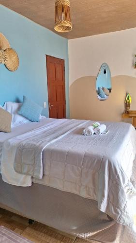 a bedroom with a large bed with a blue wall at Pipa Centro in Pipa