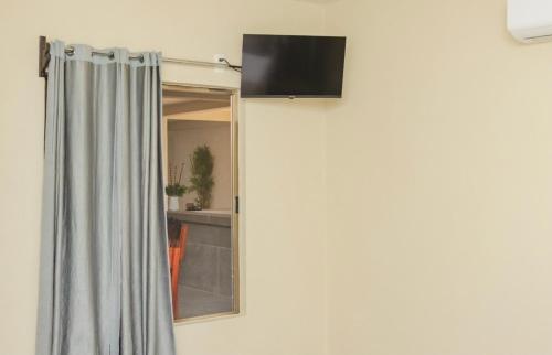 ein Zimmer mit Duschvorhang und Fenster in der Unterkunft Hotel & Suites JM in Orizatlán
