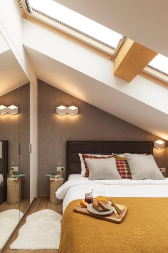 a bedroom with a bed with a tray of food on it at Apartament Stary Drewniany Białka Ski Resort -obok Termy Bania i Kotelnica in Białka Tatrzańska