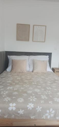 a bedroom with a bed with white flowers on it at Wzgórze za miedzą - Niezależne Studio z osobnym wejściem in Sicienko
