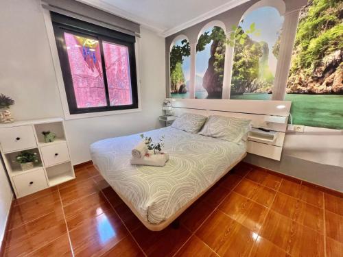 a bedroom with a large bed with two windows at Casa baja a la playa in Bueu