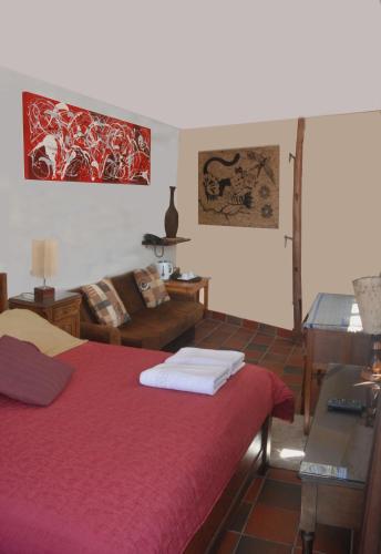 a bedroom with a red bed and a couch at Rendezvous Hostal in La Paz