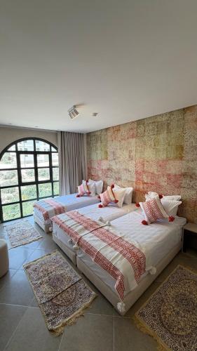 two beds in a room with rugs in it at HoneyPath Ocean Retreat in Tamraght Ouzdar