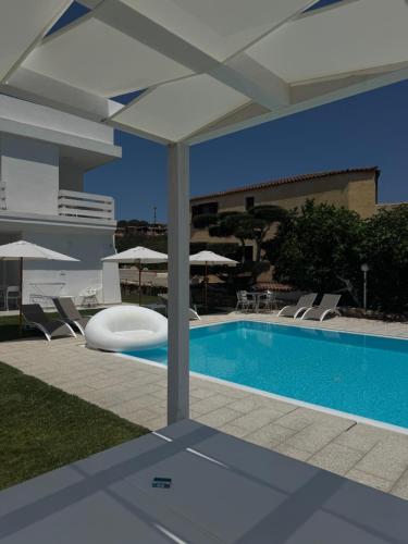 a swimming pool with chairs and an umbrella at Al Mare da Francesca in Olbia