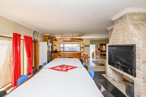a large dining room with a long table and a fireplace at Diamond Style Guesthouse in Gqeberha