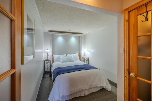 a bedroom with a bed and two lights on the wall at Auberge des 21 in La Baie
