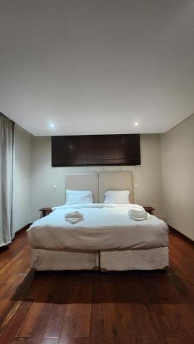 a bedroom with a large bed with white sheets at ORO - Boutique Guesthouse in Matola