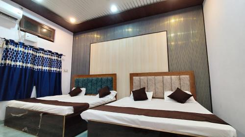 two beds in a room with blue curtains at Ma jamwanti homestay in Ayodhya