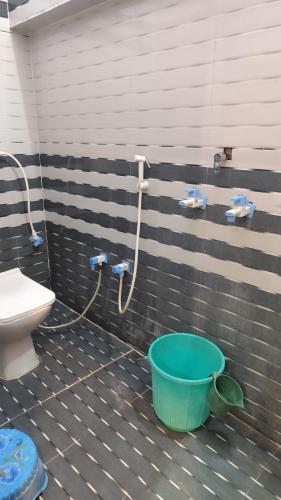 a bathroom with a toilet and a bucket at Ma jamwanti homestay in Ayodhya