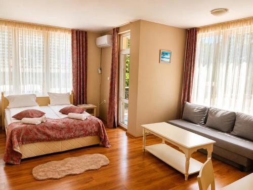 a bedroom with a bed and a couch at Liora studio apartments in Sunny Beach